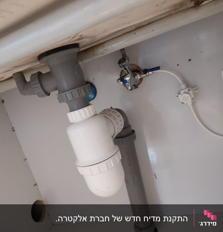 צנרת פלסטיק מתחת לכיור עם ברזים וחיבורים